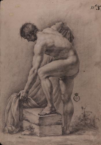 Estudio de modelo masculino desnudo con el pie izquierdo sobre un bloque semi agachado cogiendo un paño